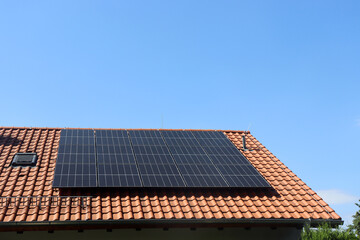 Solaranlage auf einem Einfamilienhaus mit blauem Himmel in Deutschland	