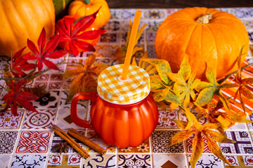 Pumpkin spice hot autumn drink beverage. Nearby fall leaves, pumpkins