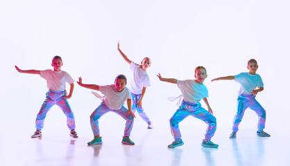 Team of girls wearing style clothes with trendy, creative hairstyle dancing synchronous in...