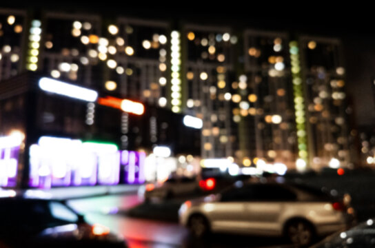 Blurred background. Night city. Blurred silhouette of buildings, bokeh spots of glowing lanterns. Blurred view of city street.Bokeh effect. Defocused night street with bokeh blur of street lights