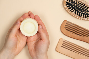 Solid shampoo in female hands. Natural eco-cosmetics without plastic for the hair care - obrazy, fototapety, plakaty