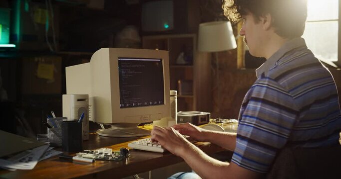 Zoom In Shot Of Caucasian Male Hardware Engineer Programming On Old Desktop Computer In Retro Garage. Experienced Software Developer Writing Code For New Innovative Operating System In Nineties.