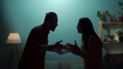 Angry man and woman are arguing in the living room. Silhouette of aggressive nervous couple arguing at home - Powered by Adobe