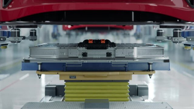 Generic EV Battery Pack on Production Line being Lifted and Installed on Electric Car. Modern Smart Factory. Battery for Automotive Industry. Electric Vehicle Assembly Process.