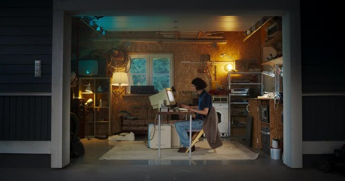 Caucasian Male Software Engineer Programming On Old Desktop Computer In Retro Garage In The Evening. Ambitious Man Starting an Innovative Fintech Startup Company In Nineties. Nostalgia Concept.