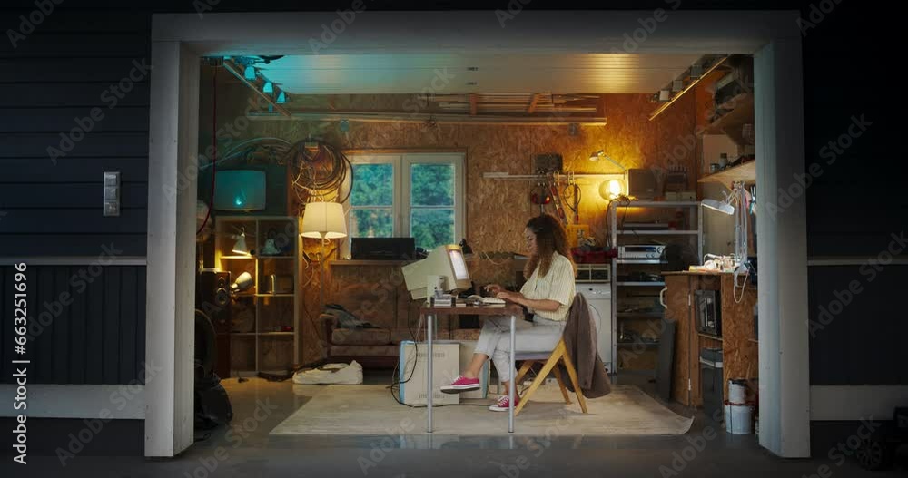 Poster hispanic female software engineer programming on old desktop computer in retro garage in the evening