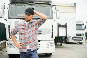 Portrait of trucker standing by his truck ready for driving. Driver occupation. Transportation services