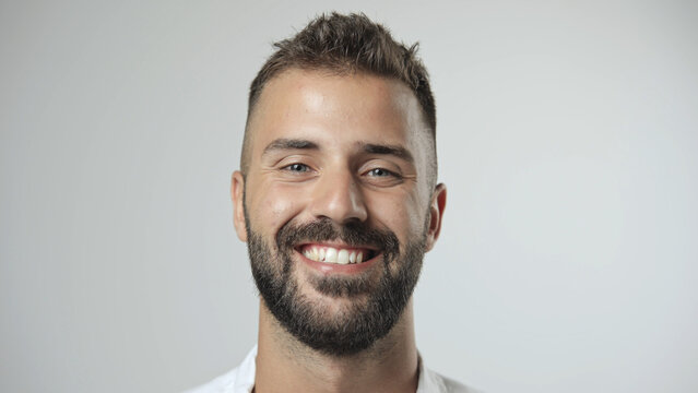 Handsome person look at camera close up. Young adult man face portrait. Stylish 30s guy on isolated white background. Attractive male model. Modern millennial people. Brutal bearded style. Barber shop