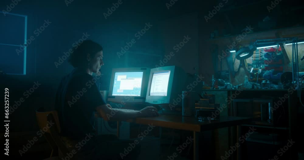 Leinwandbilder caucasian male programmer using old desktop computer with two monitors in retro garage late at night