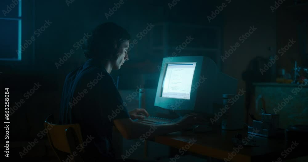 Poster caucasian male web designer using old desktop computer in retro garage late at night. focused intern