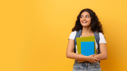 Young smiling happy indian woman student on yellow - obrazy, fototapety, plakaty
