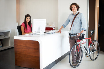 Obraz premium Man, office with bike and sustainable travel, worker in portrait with carbon footprint, transportation and creative at startup. Happy, cycling for eco friendly commute and professional at workplace