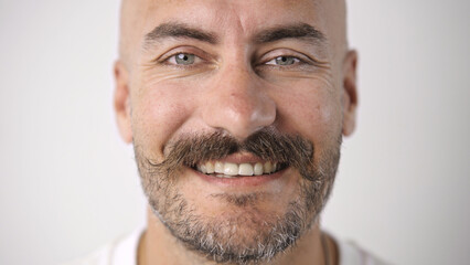 Fototapeta premium Handsome person look at camera close up. Young adult man face portrait. Stylish 30s guy on isolated white background. Attractive male model. Modern millennial people. Brutal bearded style. Barber shop