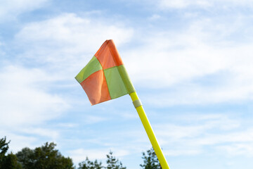 Football pitch corner flag. Square marker on a pole, positioned at the edge of soccer field. Game...