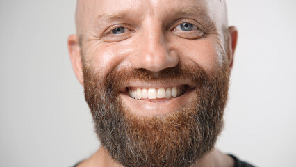 Obraz premium Handsome person look at camera close up. Young adult man face portrait. Stylish 30s guy on isolated white background. Attractive male model. Modern millennial people. Brutal bearded style. Barber shop