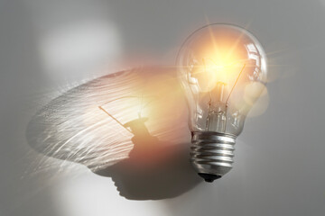 Small fluorescent light bulb. Innovation. Inspiration. Modern fluorescent light bulb on a gray...