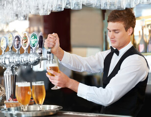 Man, bartender and waiter with beer at pub, restaurant or event for happy hour, hospitality industry or customer service. Young barman, server or catering employee with alcohol drinks in glasses - obrazy, fototapety, plakaty