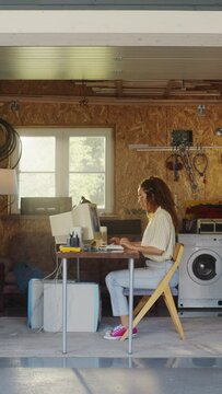 Vertical Screen: Hispanic Female Developer Programming On Old Desktop Computer In Retro Garage With Random Appliances. Young Woman Working On Innovative Online Service Startup Company In Nineties.