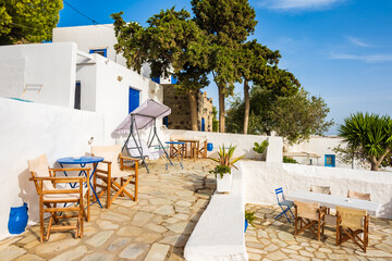 Chairs with tables on terrace with typical Greek architecture in Plaka village, Milos island, Cyclades, Greece