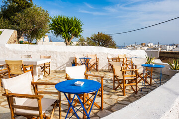 Chairs with tables on terrace with typical Greek architecture in Plaka village, Milos island, Cyclades, Greece