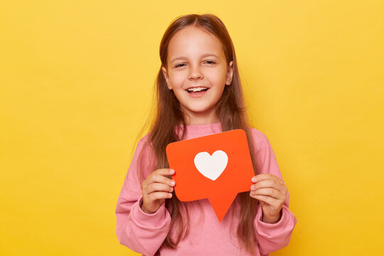 Blogging icon. Like button. Viral blog. Digital love. Share content. Smiling little girl wearing pink sweatshirt posing isolated over yellow background.