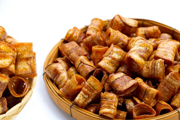 Dried banana rolled chips on white.