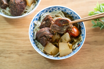 Beef noodle soup. Taiwanese famous food in a bowl on wooden table.
