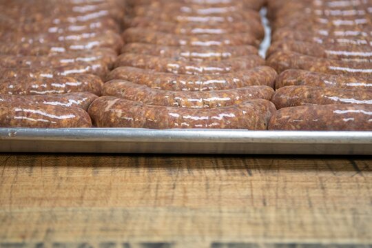 Isolated close up high resolution image of the process of creating hand made raw uncooked sausages at a boutique butcher shop- USA