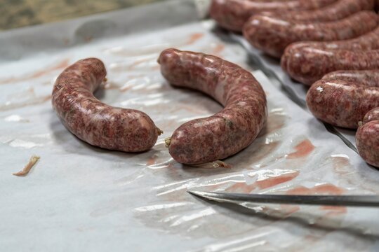 Isolated close up high resolution image of the process of creating hand made raw uncooked sausages at a boutique butcher shop- USA