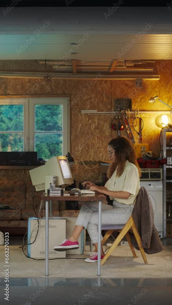 Leinwandbilder Vertical Screen: Hispanic Female Software Developer Programming On Old Desktop Computer In Retro Garage In the Evening. Woman Working On Innovative Online Service Startup Company In Nineties.