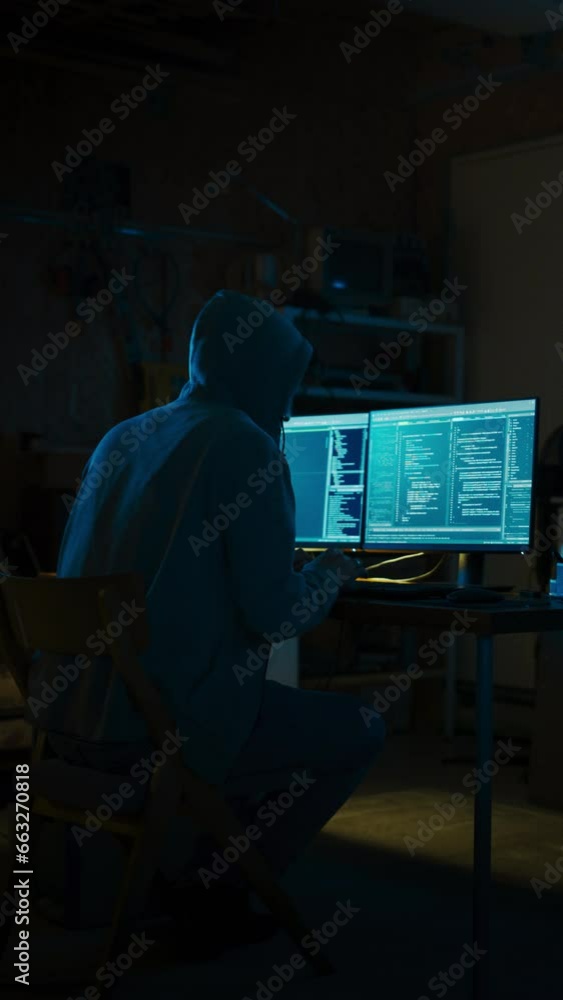 Poster vertical screen of home garage late at night: evil male hacker wearing hoodie breaks into data serve