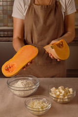 woman in kitchen brown apron cooking plant-based vegan pumpkin recipe at home