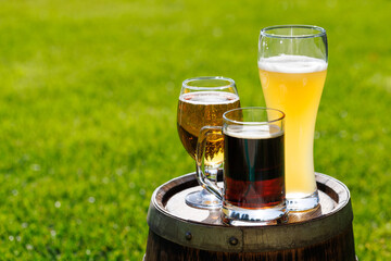 Variety of beer glasses on rustic wooden barrel