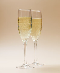 Two champagne glasses on a beige