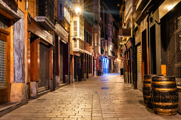 Pedestrian alley with old houses at night in the old town of Vitoria, Spain