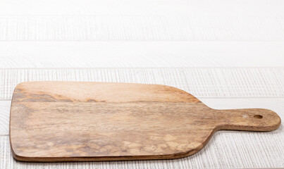 Wooden cutting board on white kitchen table