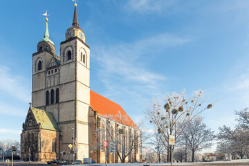 Scenic view of old St John Church in Magdeburg old city center against blue sky on cold frosty winter day. Snowy sunny german cityscape with ancient cathedral. European travel destination - obrazy, fototapety, plakaty