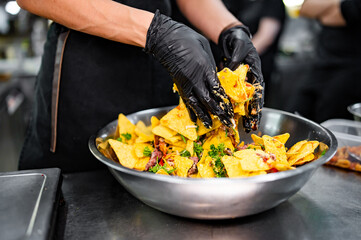 chef Cooking of crispy corn chips nachos at the restaurant kitchen