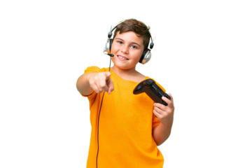 Little caucasian kid playing with a video game controller over isolated chroma key background pointing front with happy expression
