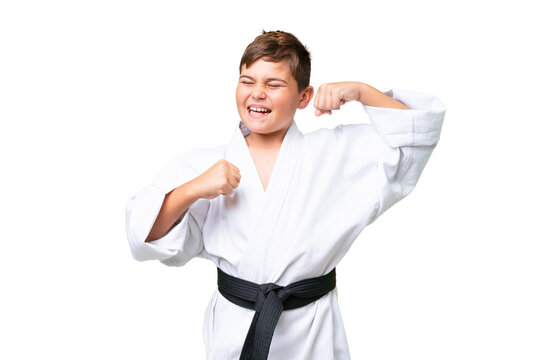 Little caucasian kid doing karate over isolated chroma key background celebrating a victory