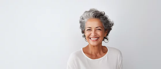 Fotobehang Portrait of a happy smiling beautiful aging mature woman with smooth healthy face skin on white background with empty copy space © RJ.RJ. Wave