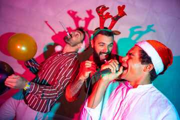 Guys having fun singing karaoke at New Year Eve party