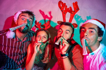 Friends blowing party whistles at New Year party