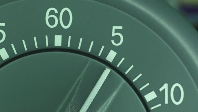 Clockwork kitchen timer close up time-lapse count down to zero.