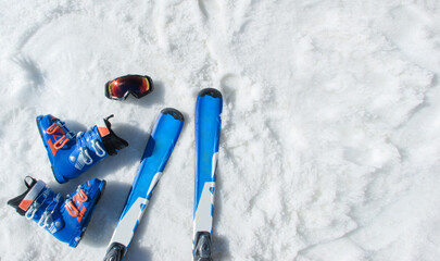 Mountain skis, sunscreen mask, ski goggles and ski boots on bright alpine snow. Winter holidays.  Extreme sport. Vacation, travel content. Copy space - obrazy, fototapety, plakaty