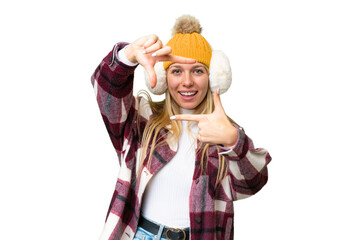 Young pretty blonde woman wearing winter muffs over isolated chroma key background focusing face....