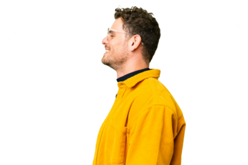 Brazilian man over isolated chroma key background laughing in lateral position