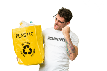 Brazilian man holding a bag full of plastic bottles to recycle over isolated chroma key background celebrating a victory