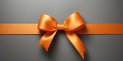 Orange gift ribbon with a bow against a gray background - obrazy, fototapety, plakaty