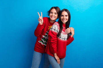 Photo of pretty friends ladies celebrate x mas make v sign isolated blue color background